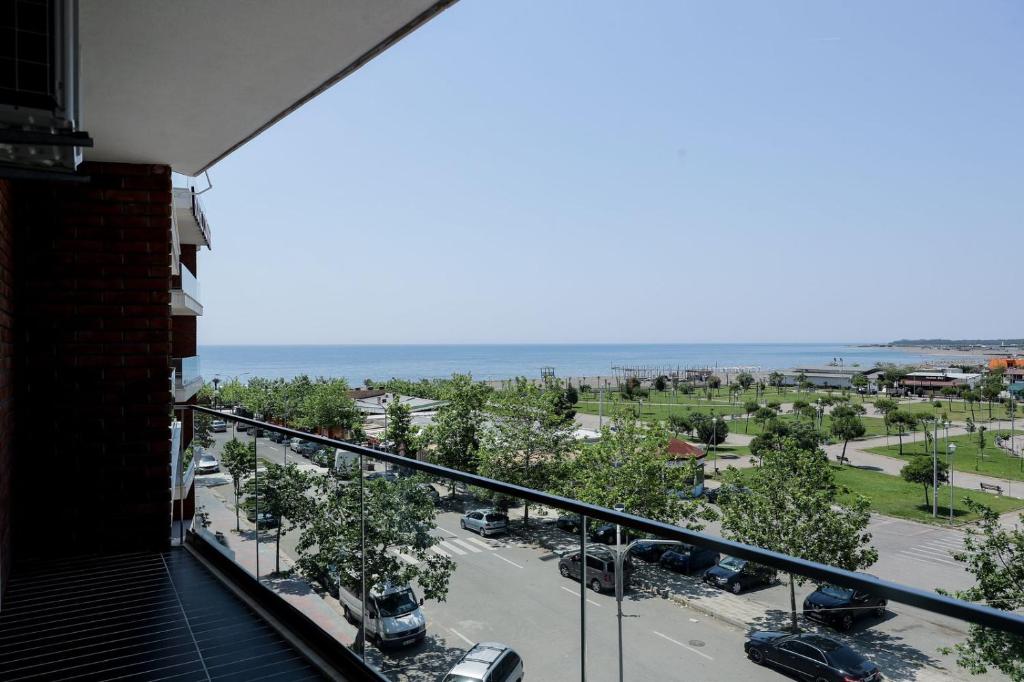 a balcony with a view of a street and the ocean at Fishta Apartments Q5 33 in Velipojë