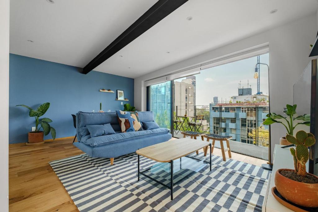 sala de estar con sofá azul y mesa en Baja California 279 Apartments, en Ciudad de México