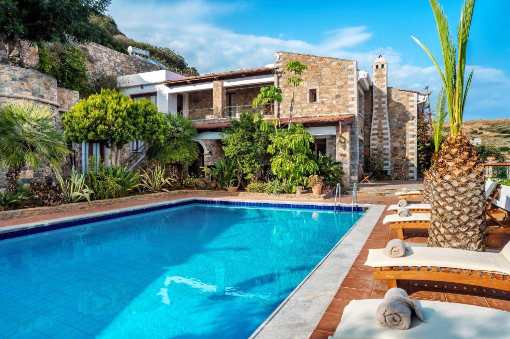 a swimming pool in front of a house at Leyla Luxury Villa in Pláka