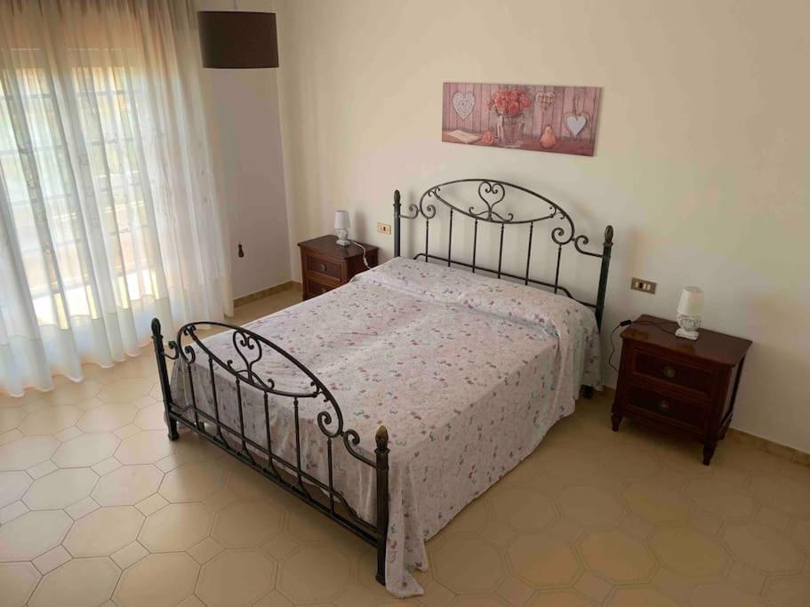 a bedroom with a large bed and two night stands at Casa Vacanza Torre di Mezzo - Alba in Marausa