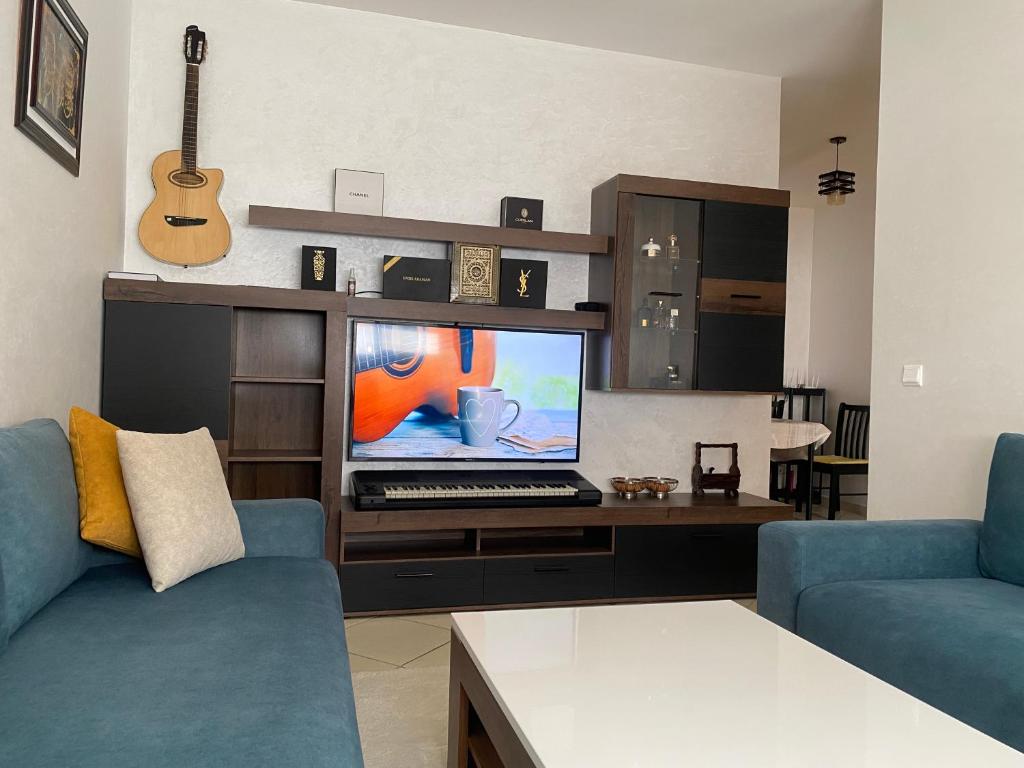 a living room with a couch and a computer on a desk at Jawharat plage des nations in Sale