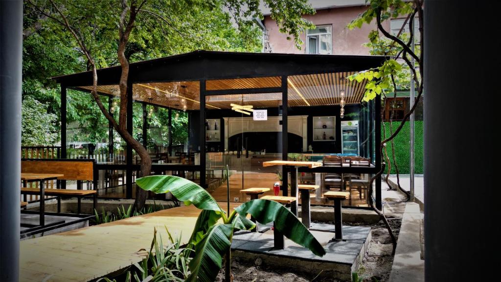 un pavillon avec une table, des chaises et des arbres dans l'établissement Hotel Salosi, à Tbilissi