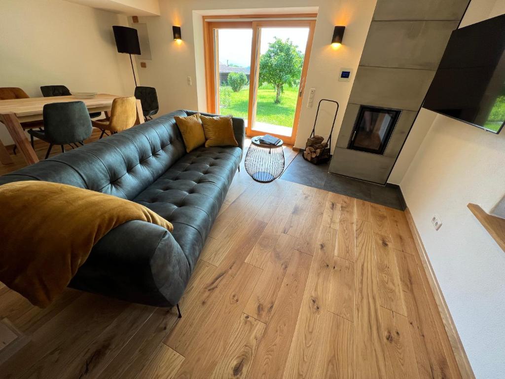 a living room with a couch and a fireplace at Beim Mühltaler II in Schleching