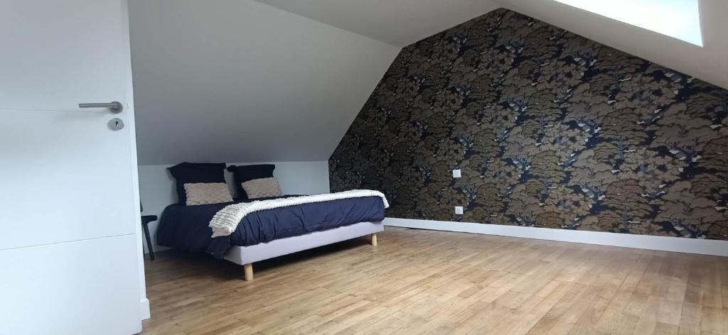 ein Schlafzimmer mit einem Bett in einem Zimmer mit einer Wand in der Unterkunft Ty Breizh jet in Ergué-Gabéric