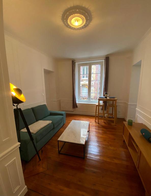 a living room with a couch and a table at Charmant appartement Rouen centre in Rouen
