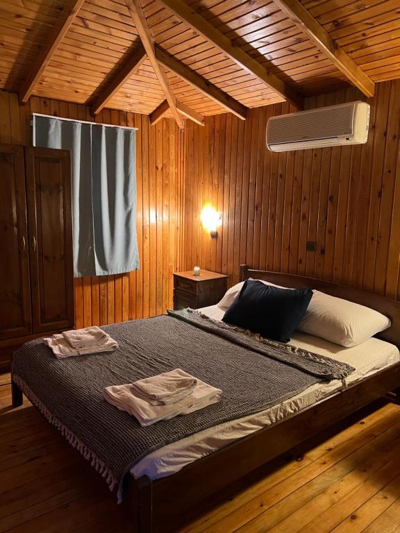 Olympos Çınar Hotel في أوليمبوس: غرفة نوم بسرير في غرفة خشبية