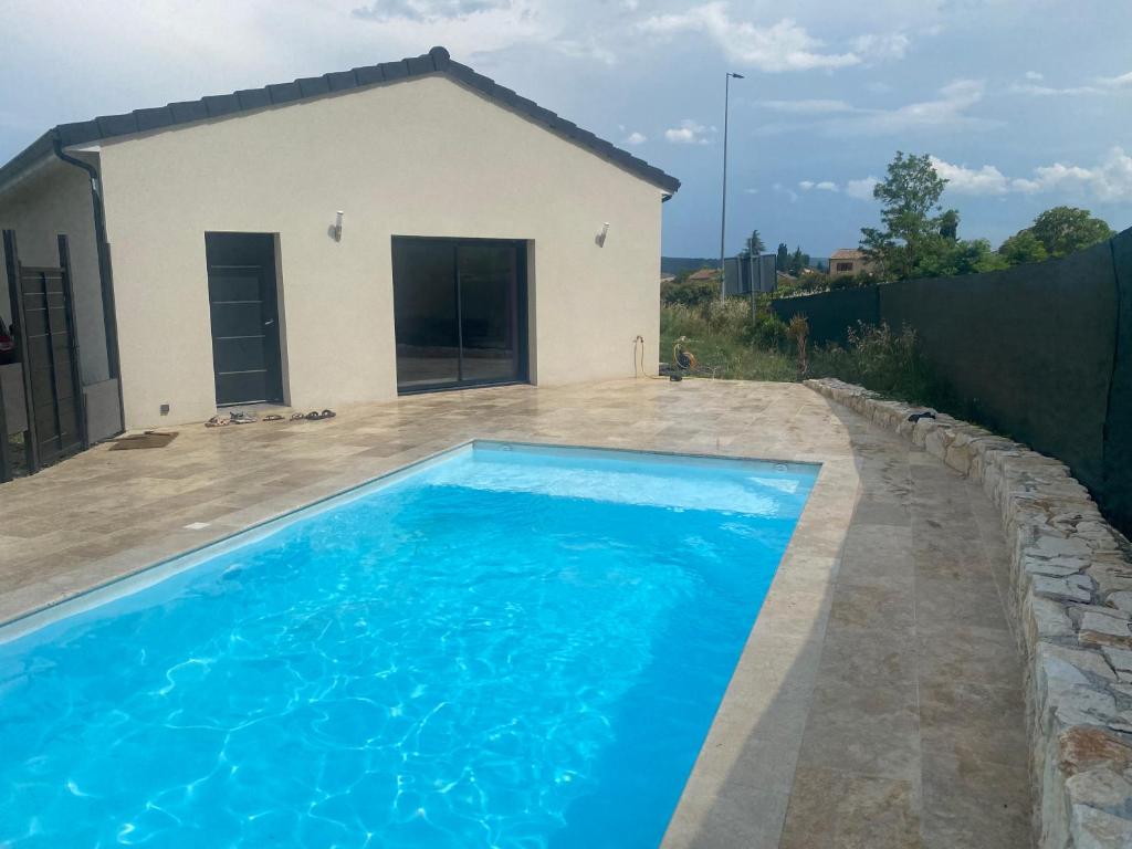 - une piscine en face d'une maison dans l'établissement Villa moderne avec piscine Aubenas, à Saint-Étienne-de-Fontbellon