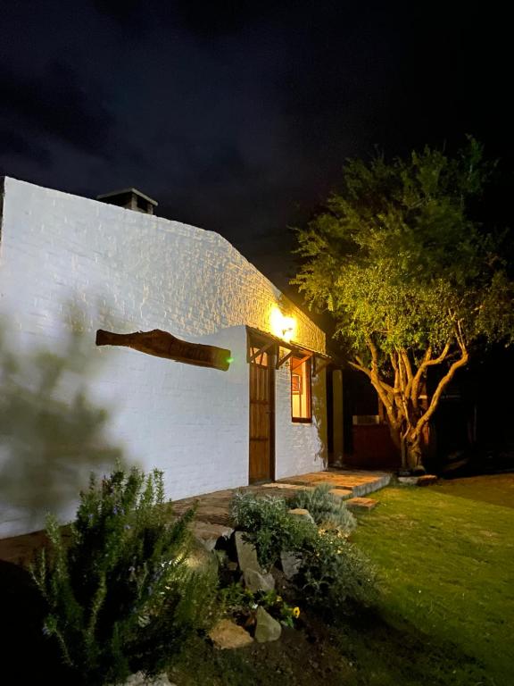 Una casa blanca con una luz en el costado. en Armonía en Villa Serrana