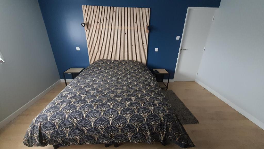 uma cama num quarto com uma parede azul em Maison La Côte em Boulogne-sur-Mer