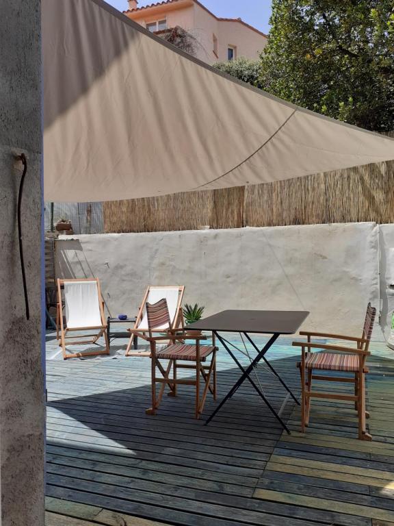 een tafel en stoelen op een terras met een tent bij Casa azul & blanca in Banyuls-sur-Mer