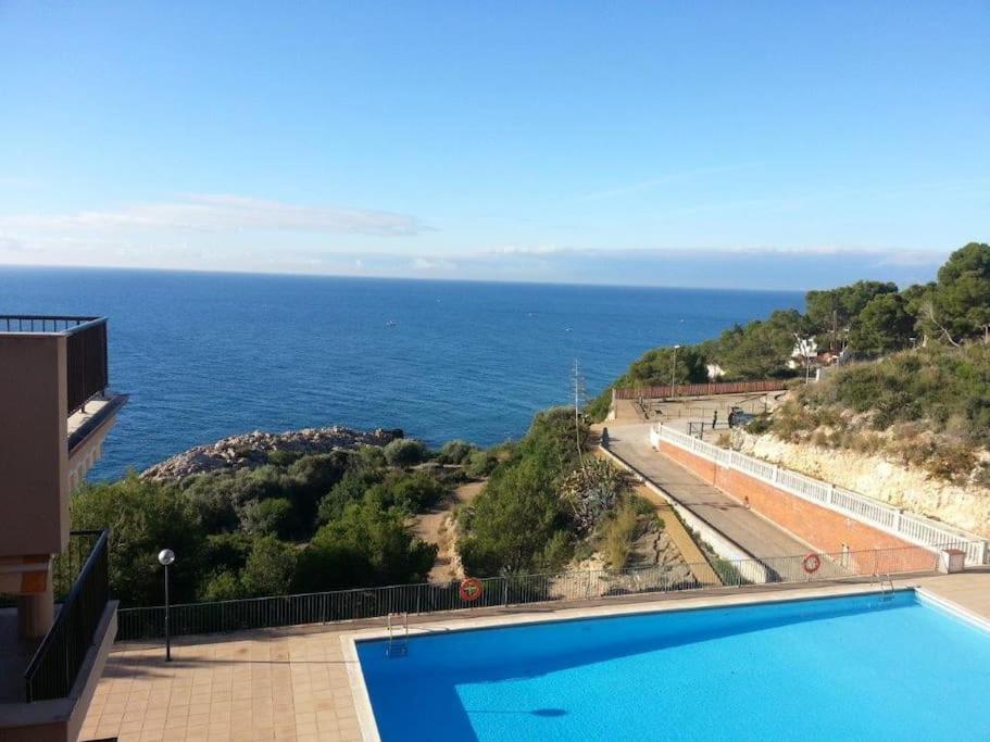 een zwembad met uitzicht op de oceaan bij Apartamento 2 habitaciones Cap Salou in Salou