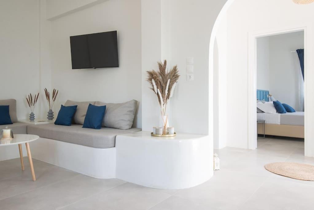 un soggiorno bianco con divano e cuscini blu di MFP Dryos Paros House Project a Drios