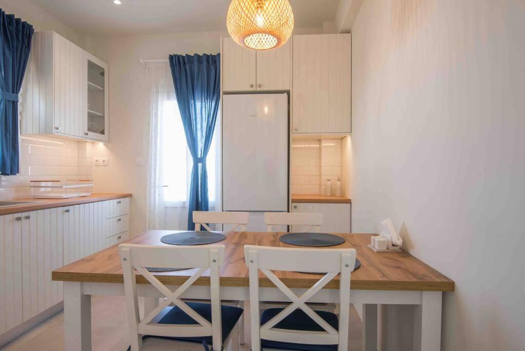 una cucina con tavolo in legno e sedie bianche di MFP Dryos Paros House Project a Drios