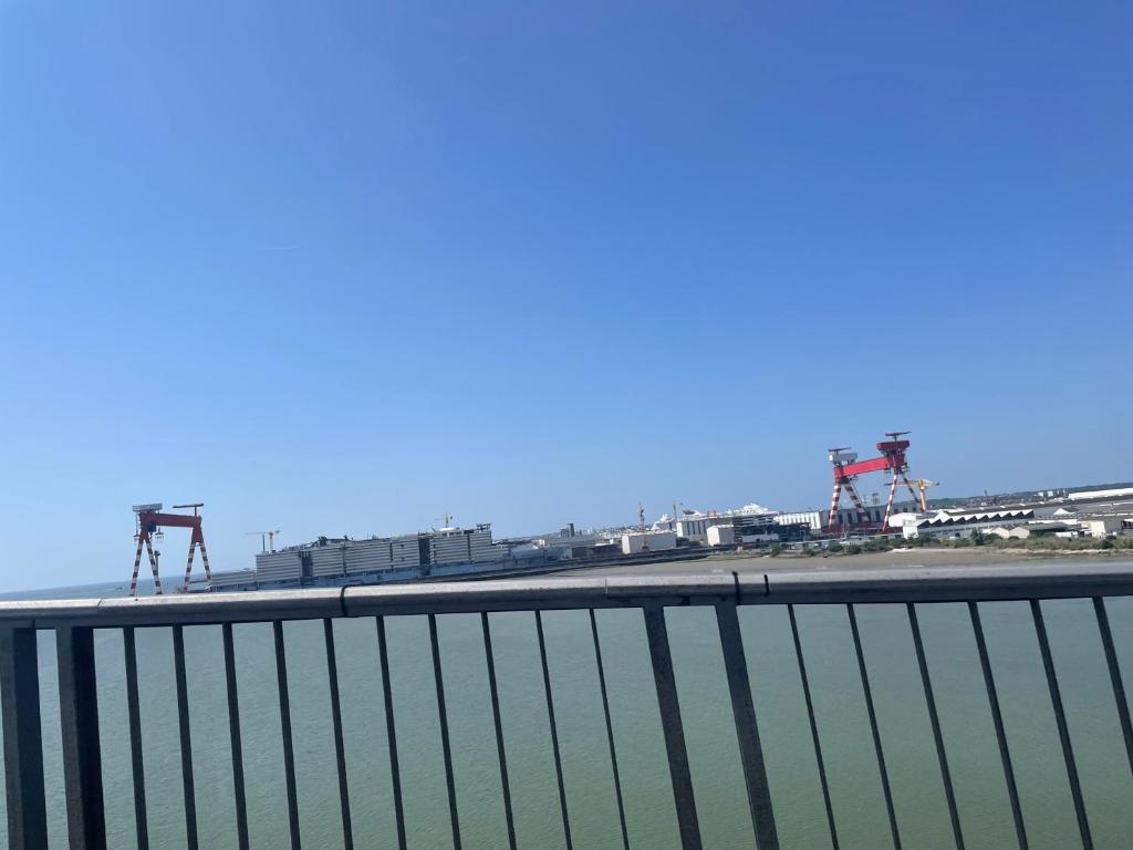 a view of a harbor with some cranes at Studio cosy avec terrasse, proche Chantiers et Airbus in Saint-Nazaire