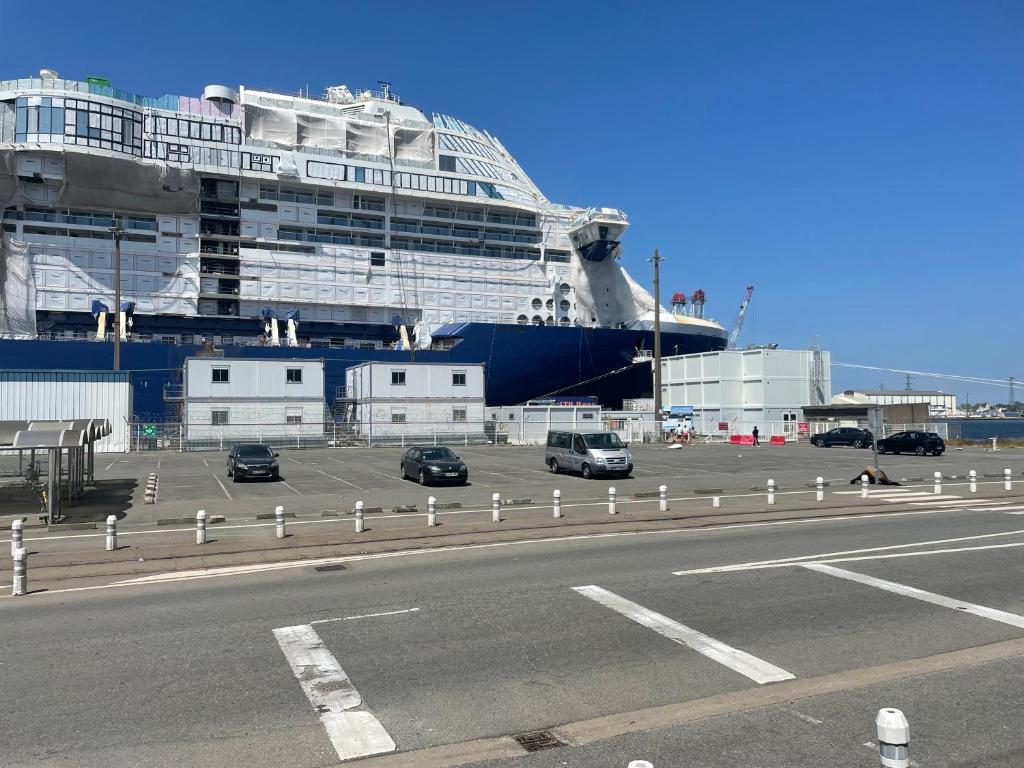 a cruise ship is docked in a parking lot at Studio cosy avec terrasse, proche Chantiers et Airbus in Saint-Nazaire