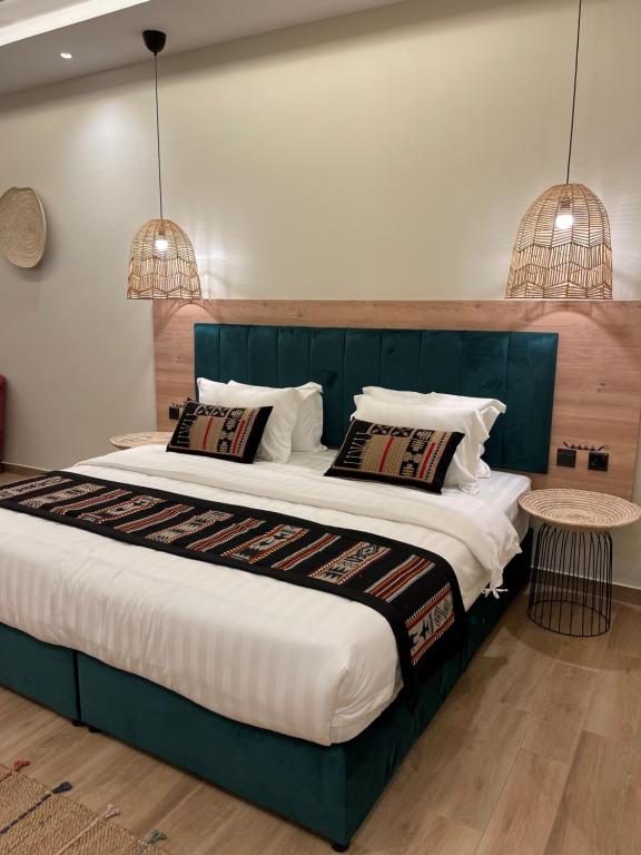 1 dormitorio con 1 cama grande y 2 luces colgantes en ريف سويت للأجنحة الفندقية en Abha