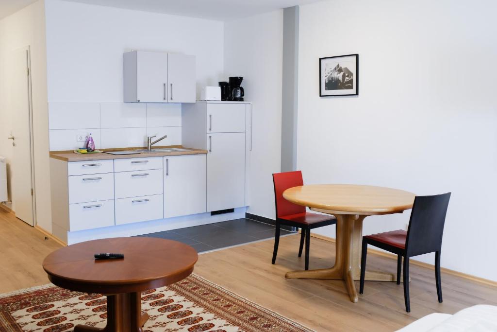a kitchen with a table and chairs in a room at Milchhof Apartments Aschaffenburg in Aschaffenburg