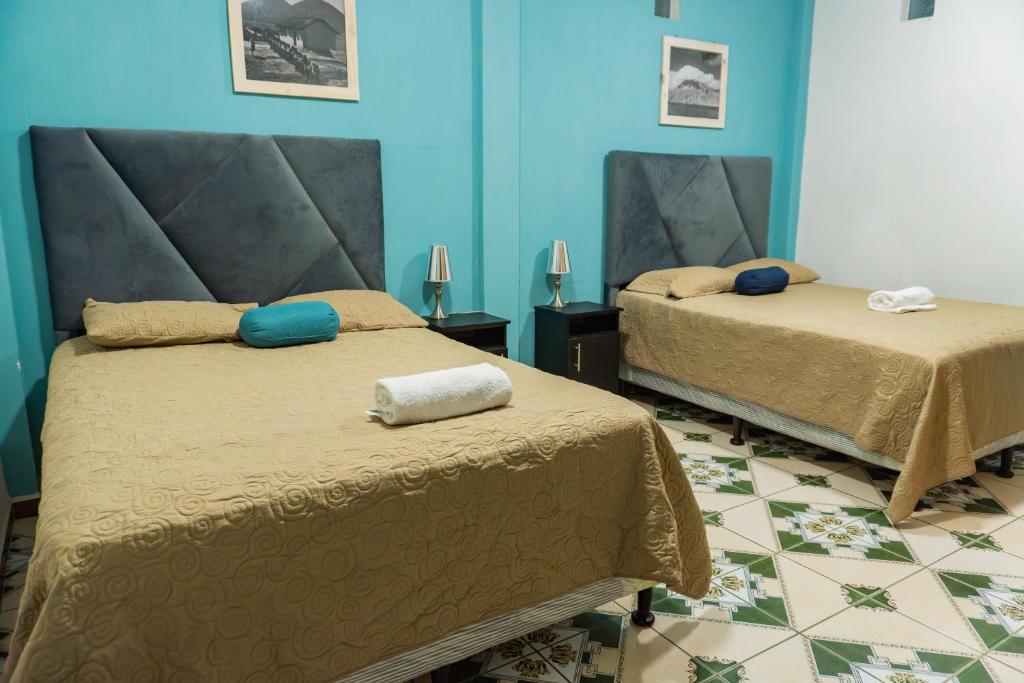 Duas camas num quarto com paredes azuis em Atitlan´s House em Panajachel