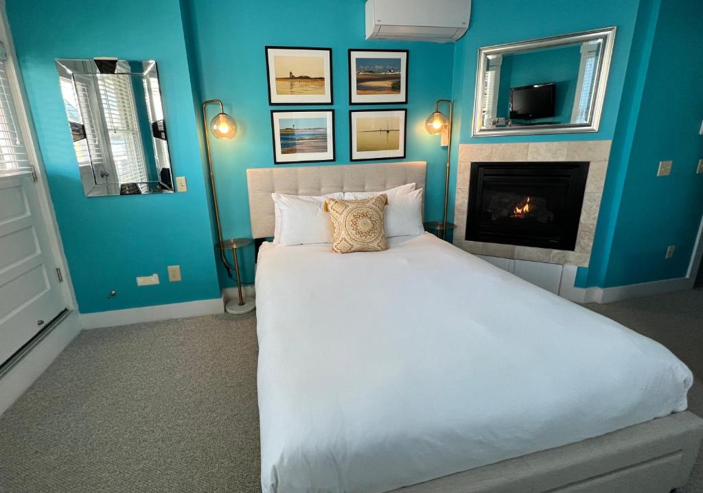 a blue bedroom with a bed and a fireplace at Lotus Provincetown in Provincetown