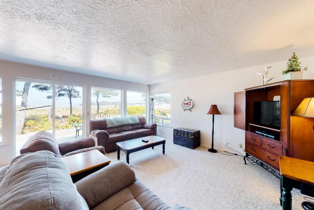 uma sala de estar com um sofá e uma televisão em Beach Time Getaway em Lincoln City