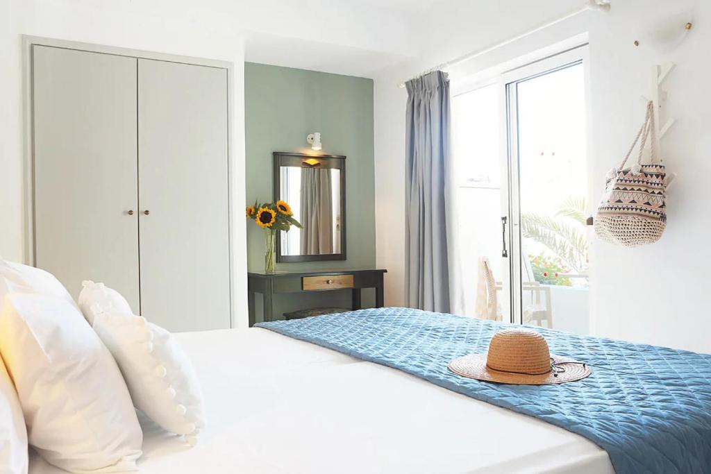 een slaapkamer met een bed met een hoed erop bij Mediterranea Apartments in Kato Daratso