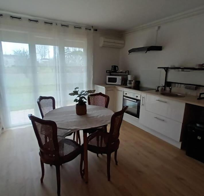 una cocina con mesa y sillas y una cocina con mesa y mesa. en La maison de Lili, en Colayrac-Saint-Cirq