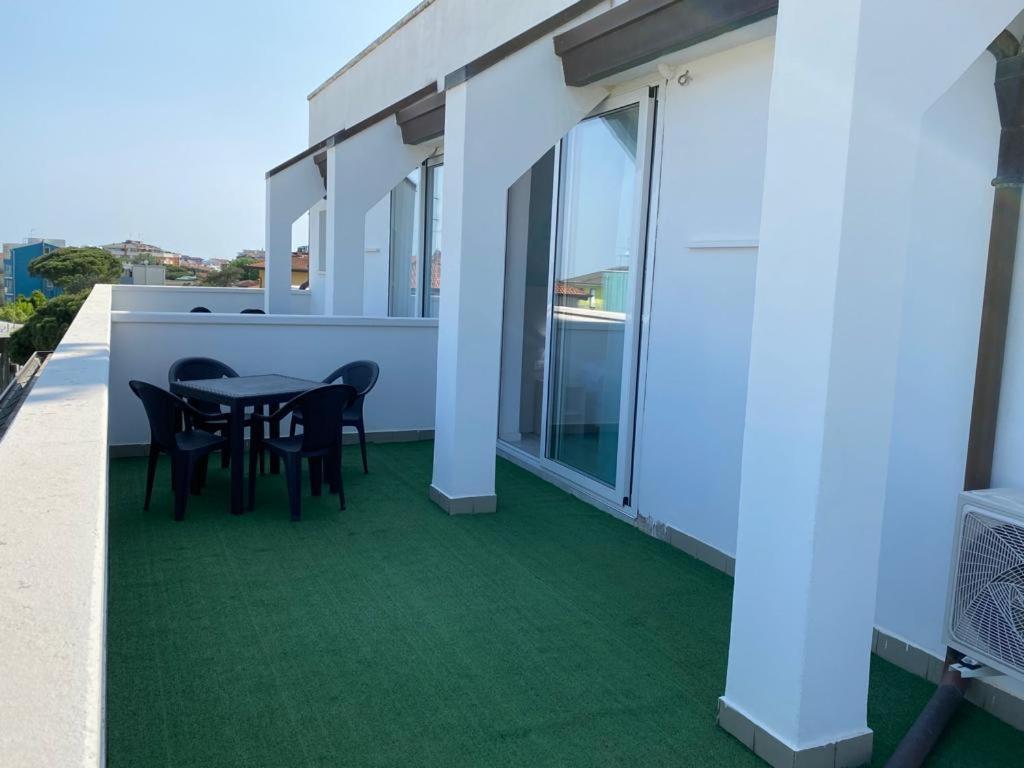 a balcony with green flooring and a table and chairs at Hotel Bahia in Caorle