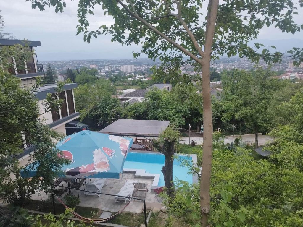uma vista para uma piscina com um guarda-sol em hill-fort kutaisi em Kutaisi