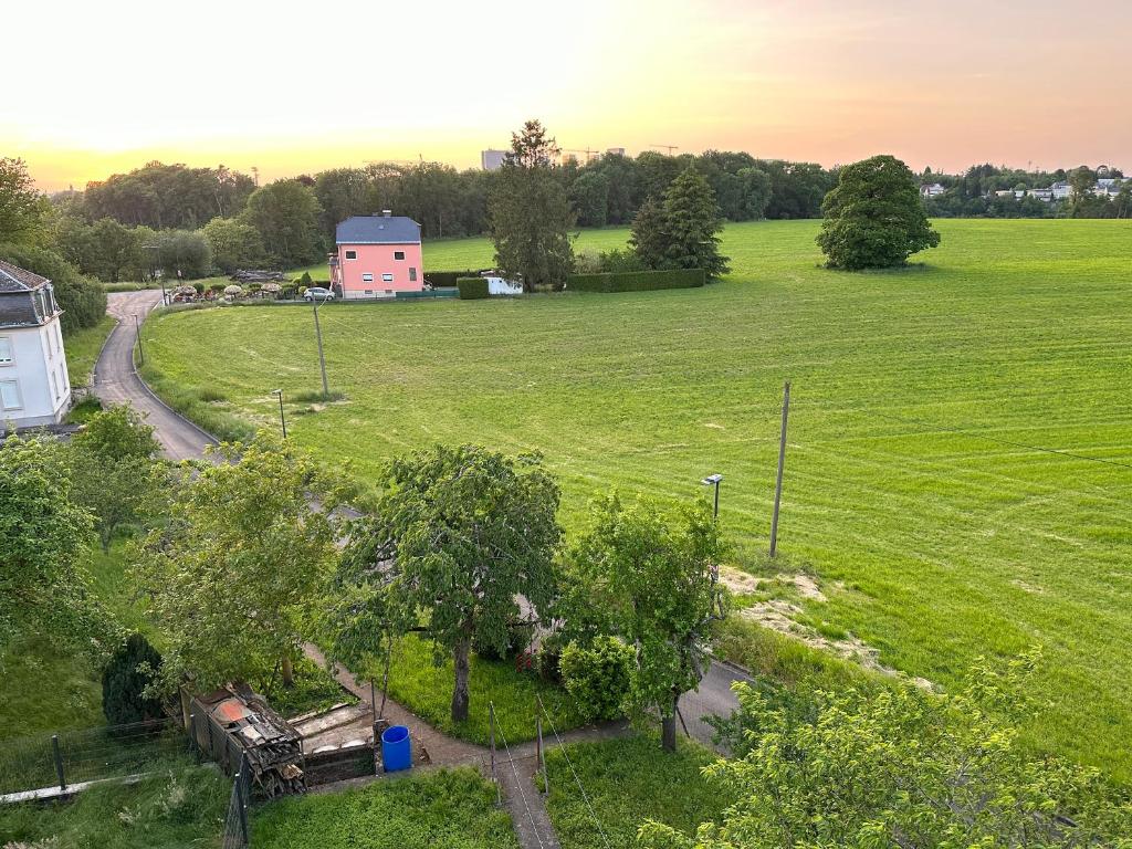 an aerial view of a field with a pink building at Good connection Airport & City in Luxembourg