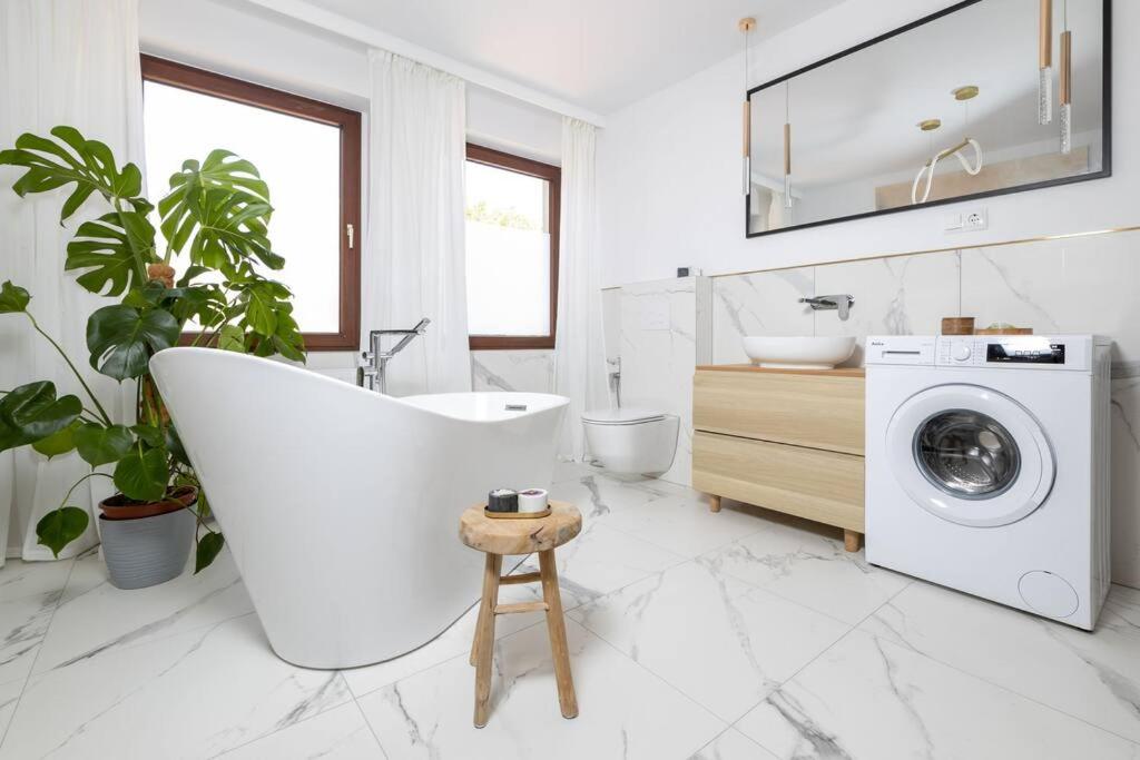 een badkamer met een wit bad en een wasmachine bij Design & Relax #Altstadt #Sauna in Lutherstadt Wittenberg