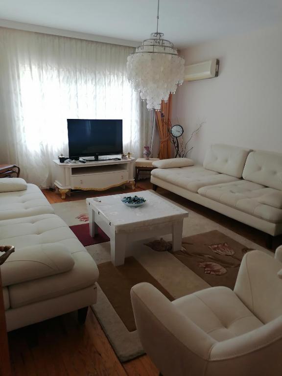 a living room with white couches and a tv at Pasa doga villa in Kumluca