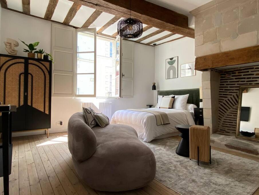 una camera con letto, divano e sedia di GUSTAVE - Quartier Historique a Nantes