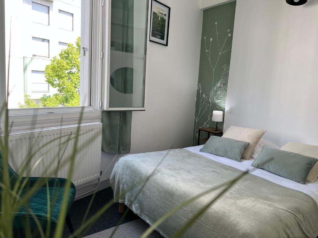 a bedroom with a bed and a window at Hotel TULTY in Tours