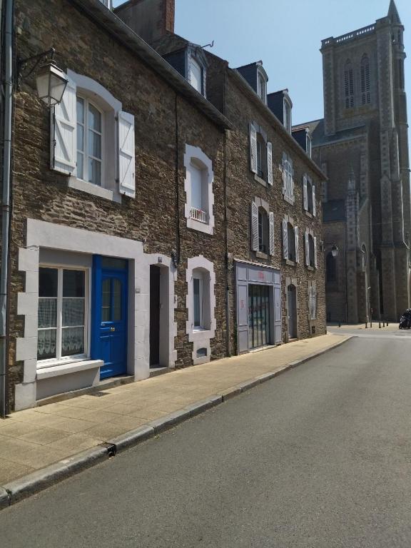 une rue vide devant un bâtiment en briques dans l'établissement LA PORTE BLEUE, à Cancale