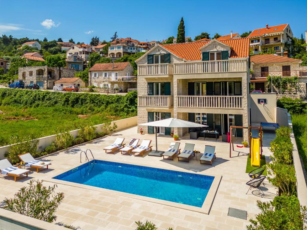a villa with a swimming pool and a house at Villa Janie - Luxury Multi-Level Estate with Pool in Supetar