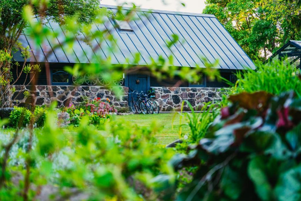 ein Haus mit einer blauen Tür in einem Garten in der Unterkunft Uue-Ringi Holiday in Puise