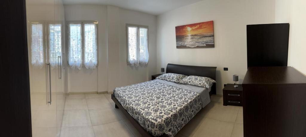 una camera con un letto in una stanza con finestre di Ca' Dei Pescatori dalle spiagge Lavagna a Lavagna