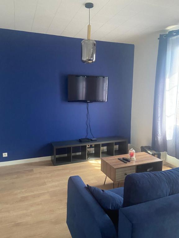 聖阿芒蒙特龍的住宿－Le Billeron，蓝色的客厅配有沙发和桌子