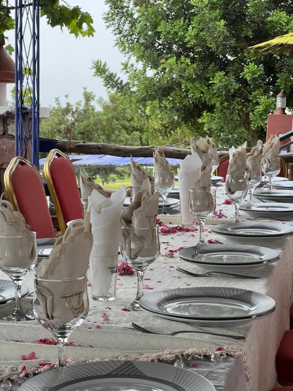 a table with plates and wine glasses on it at maison d'hôtes yamine in Beni Mellal