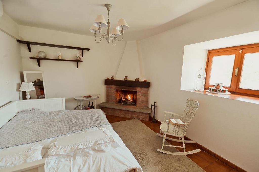 Vara Superiore的住宿－La perla nella foresta，一间卧室配有一张床和一个壁炉