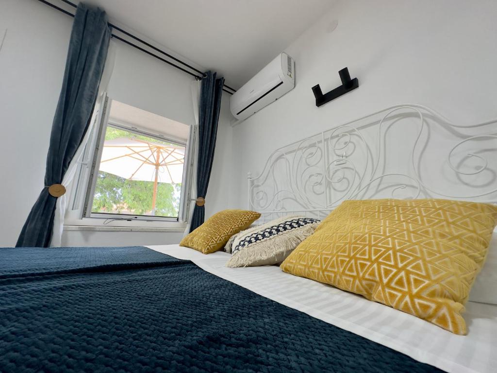 a bedroom with a bed with a large window at Matek family & studio apartment Rovanjska in Rovanjska