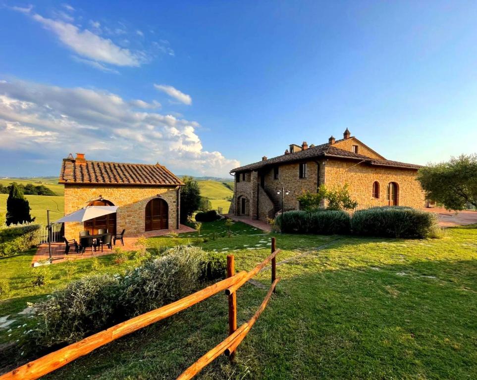 a farmhouse with a fence in front of a building at Poggio Giulia in Montaione