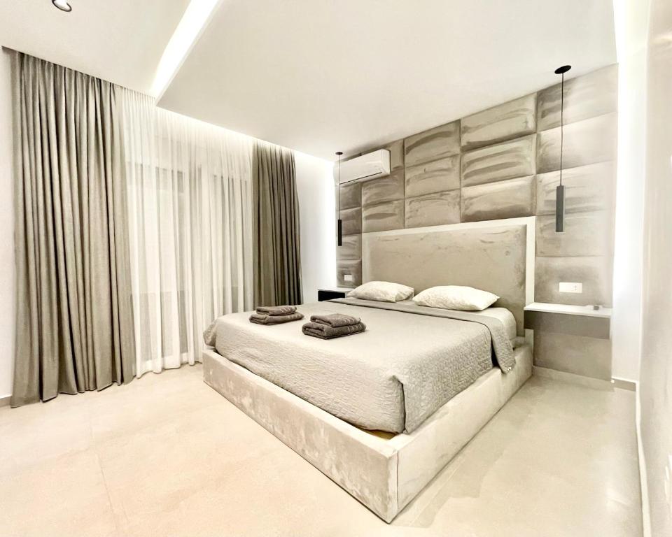 um quarto com uma cama e uma grande janela em White House Kokas Luxury Apartments em Kremasti