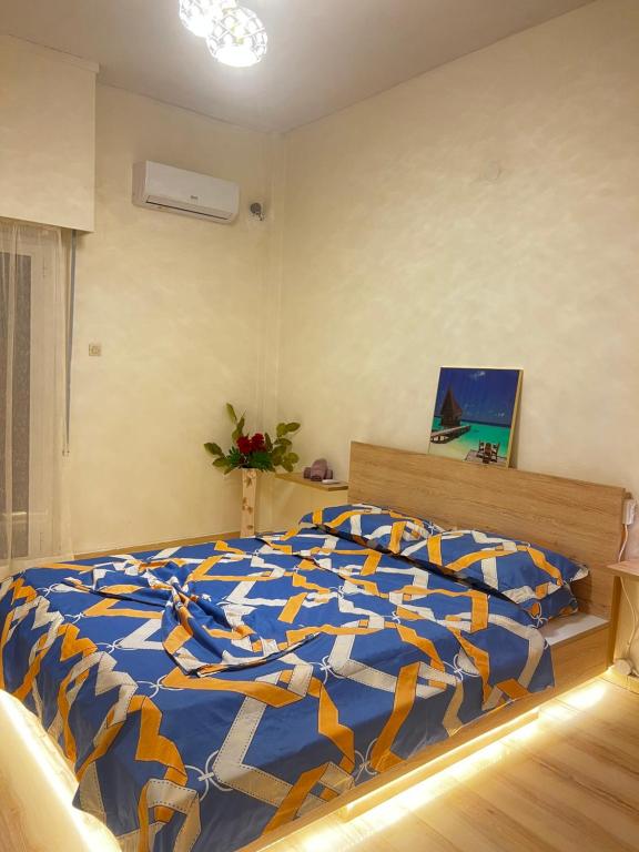 1 dormitorio con 1 cama con edredón azul y amarillo en 一线海景房seaview apartment, en Artemida