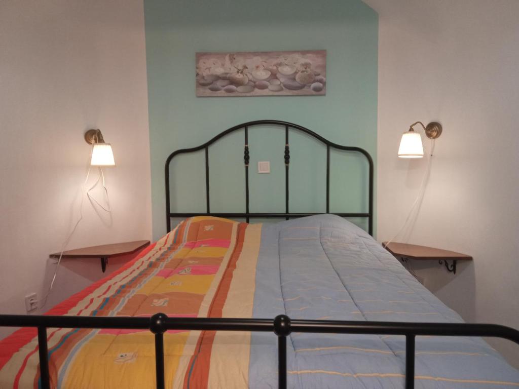 Un dormitorio con una cama con dos luces. en GS APARTMENT, en Gythio