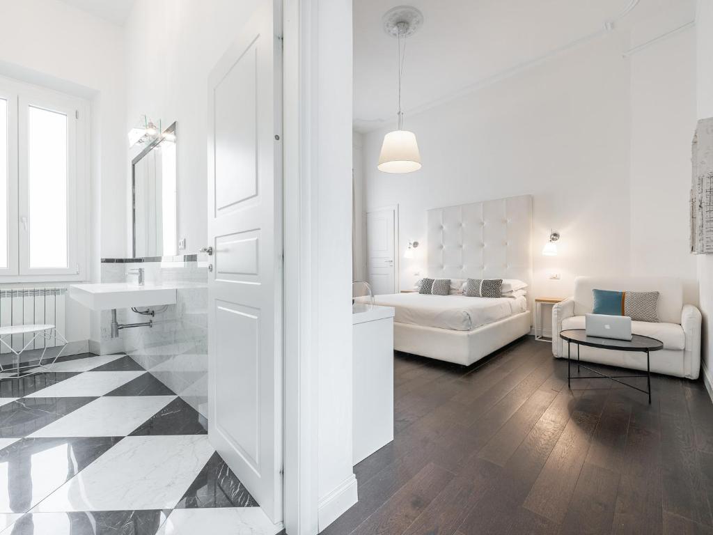 a white living room with a sink and a couch at PLEY Cagliari Boutique Suites in Cagliari