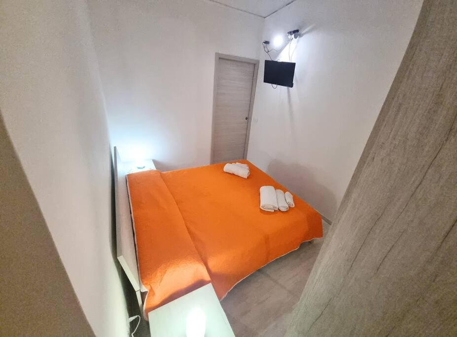 una piccola stanza con un letto arancione con due asciugamani di Omarvulcano1 - PROPPRO - isole eolie a Vulcano