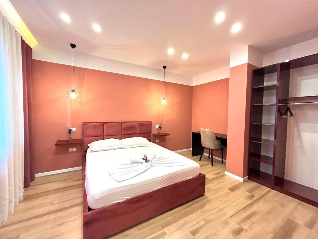 a bedroom with a large bed and a desk at Belix Seaview Apartments in Durrës