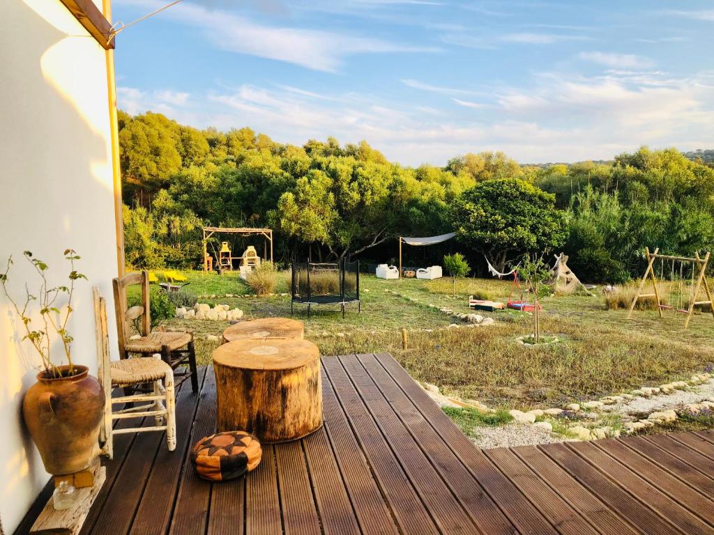 a wooden deck with a table and a tree stump at RuralCaMomo in Cádiz