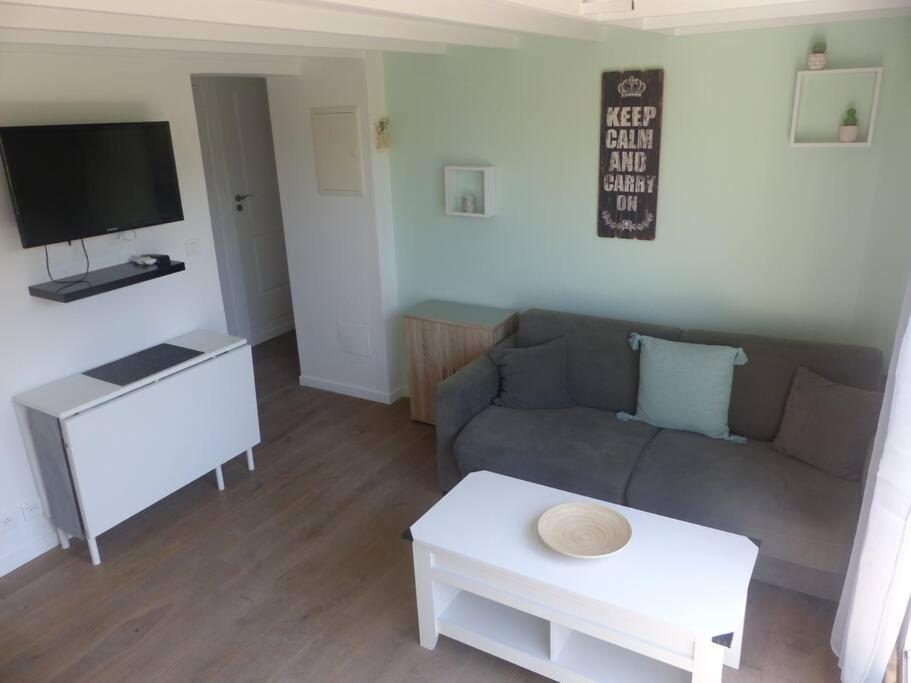 a living room with a couch and a table at Logement idéal au centre-ville in Cavalaire-sur-Mer